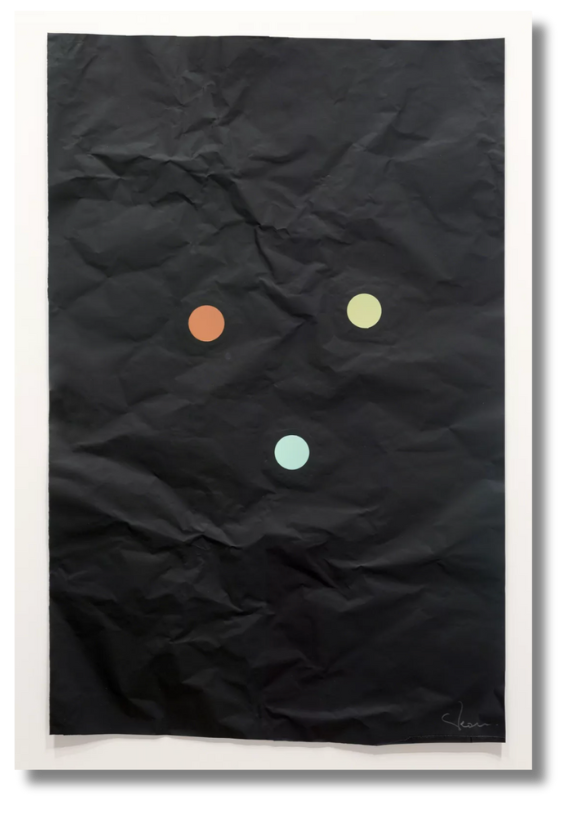 Black crinkled paper artwork with three minimalist colored dots arranged in a triangle formation.