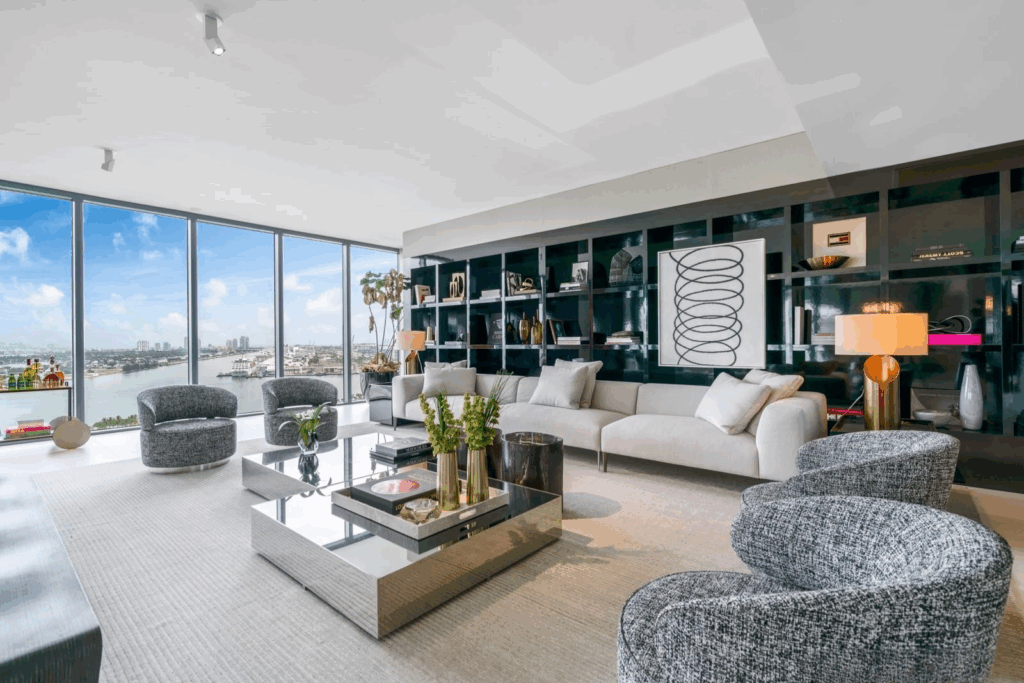 Detailed interior view featuring curved lounge chairs, brass accents, and curated art collection in a waterfront tower.