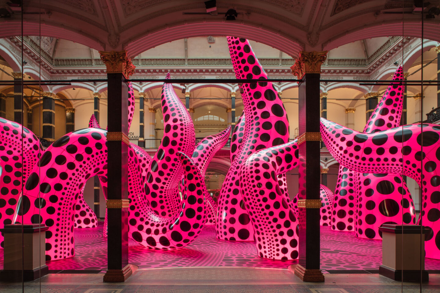 Installation view of Yayoi Kusama's inflatable tentacle sculptures in vivid pink with black polka dots, exhibited at Gropius Bau, 2021.