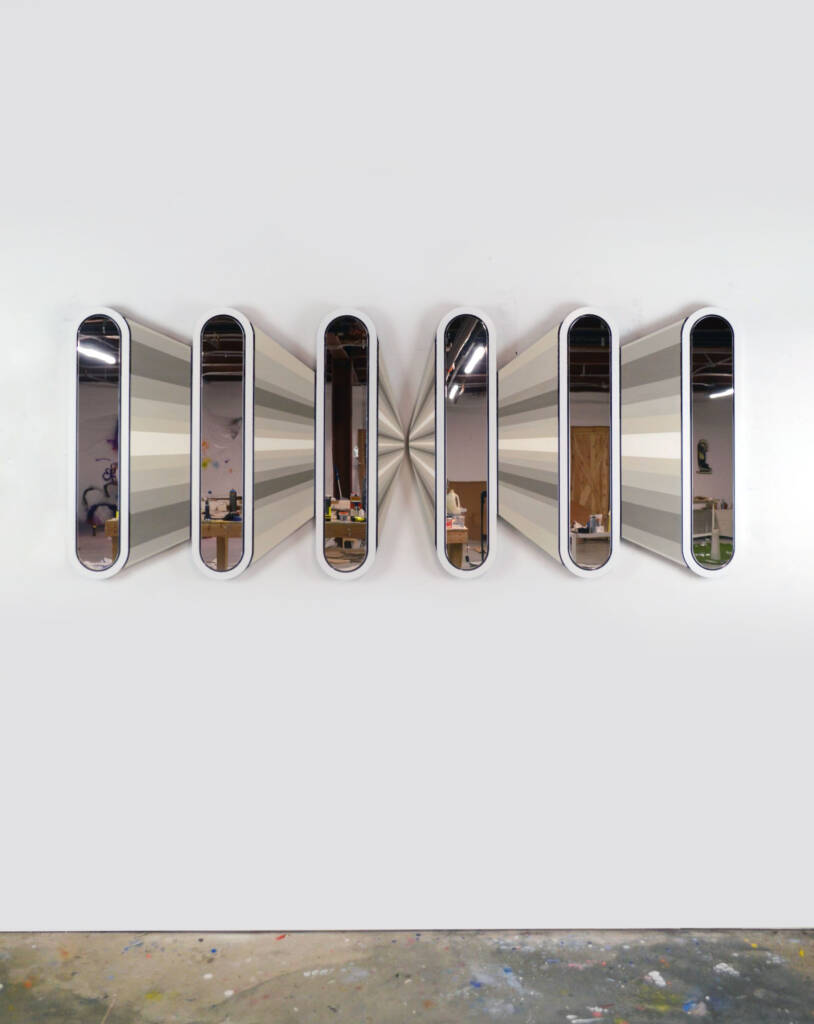 sculptural installation with mirrored panels and radial grayscale lines