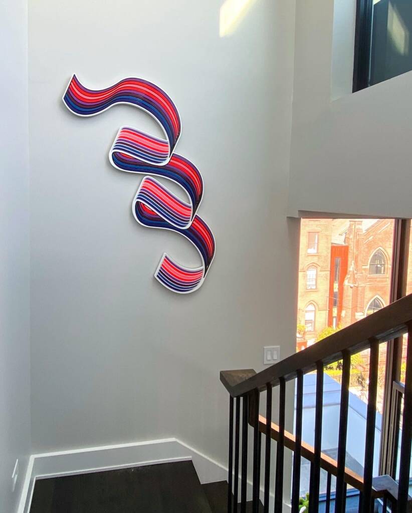 Jenna Krypell sculptural painting installed in a modern staircase, featuring red, white, and blue curving lines