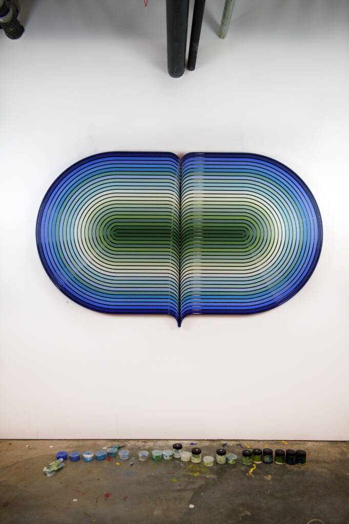 Large-scale sculptural artwork in gradient blues and greens with a radiating center