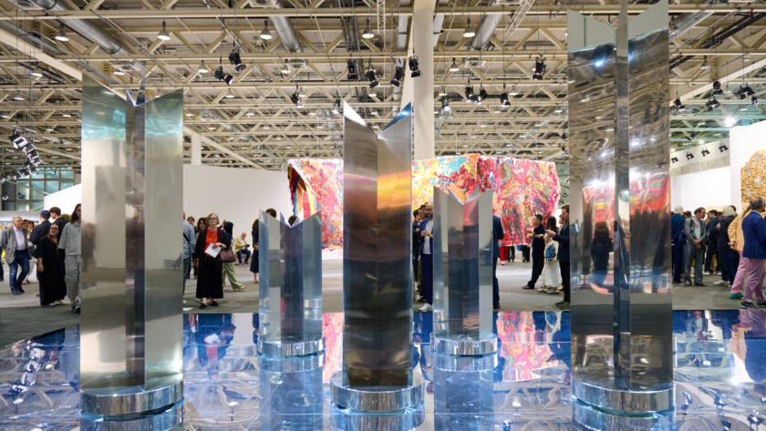 Polished metal sculptures by Heinz Mack presented by Almine Rech at Art Basel 2025, reflecting light across a mirrored blue floor installation.