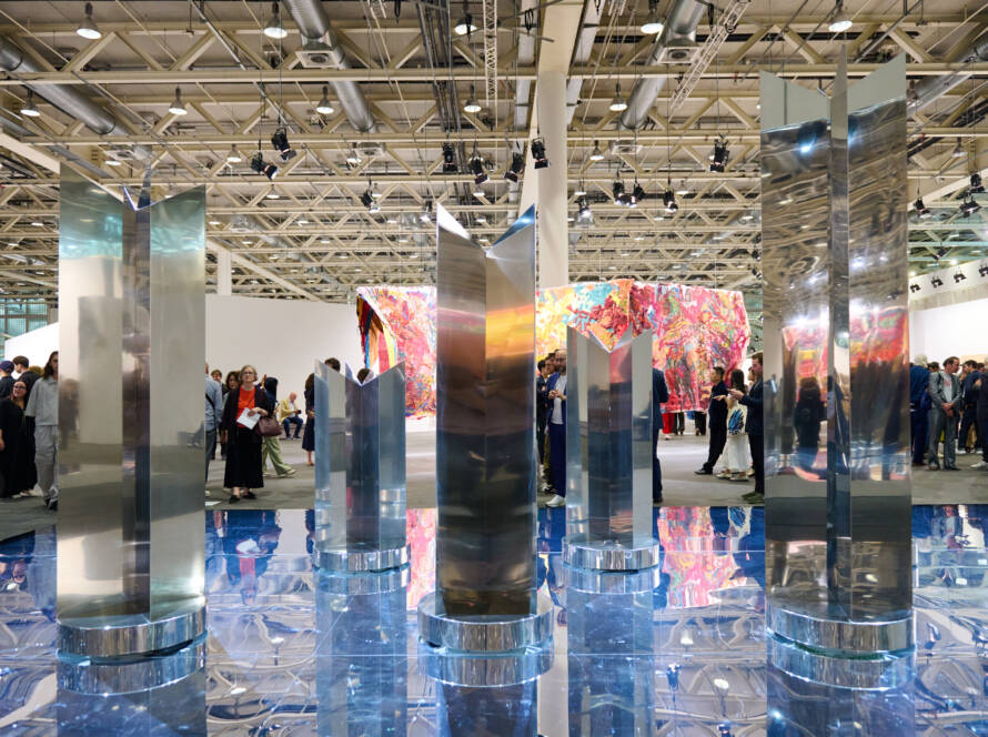 Polished metal sculptures by Heinz Mack presented by Almine Rech at Art Basel 2025, reflecting light across a mirrored blue floor installation.