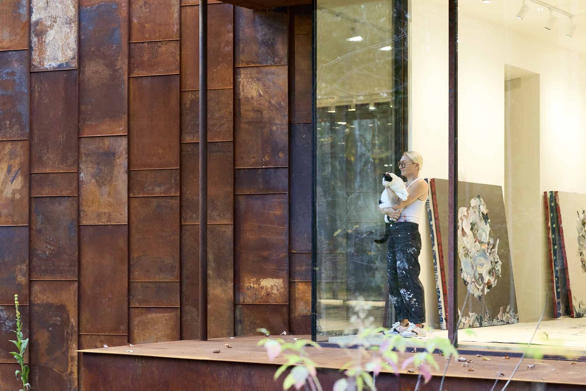 a photograph of Janna watson holding her cat in her house surrounded by artwork
